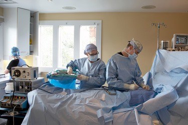 Medical staff in scrubs working on patient in operating room